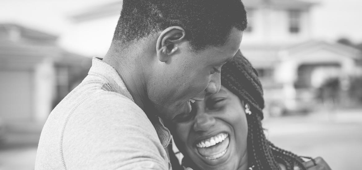 Black couple laughing and embracing.